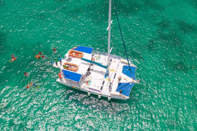 Image of catamaran cruise and people swimming